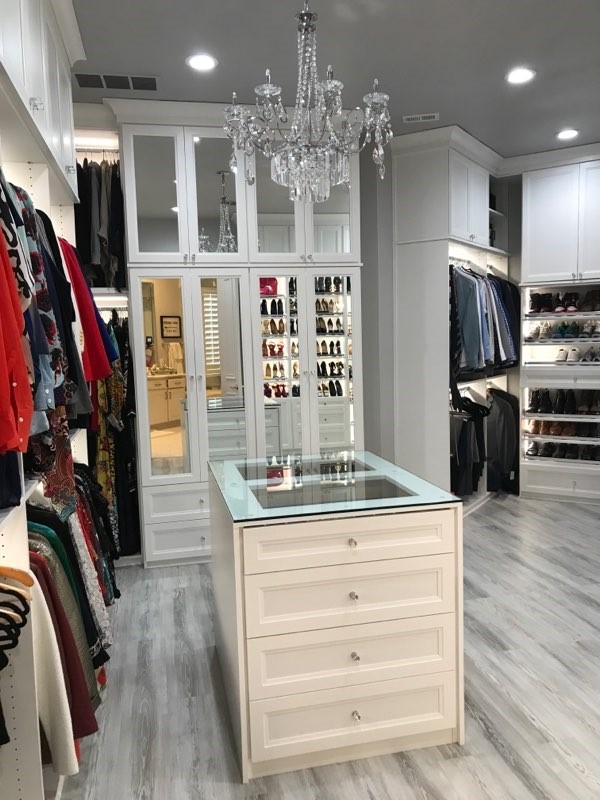 Ejemplo de armario vestidor unisex tradicional renovado grande con armarios tipo vitrina, puertas de armario blancas y suelo gris