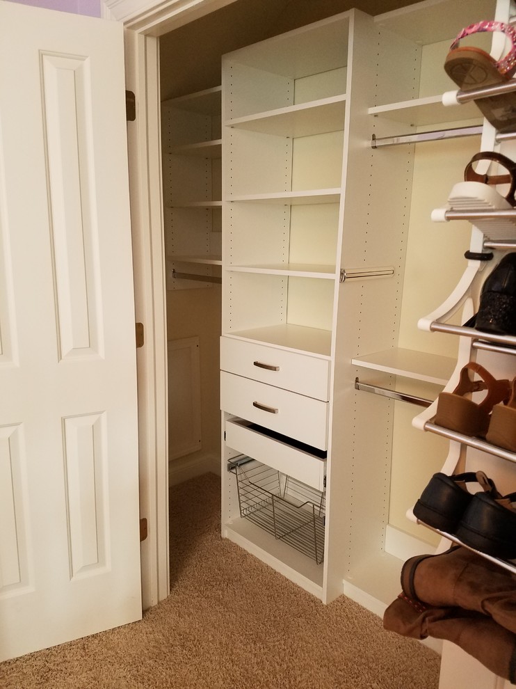 Foto de armario unisex clásico pequeño con armarios abiertos, puertas de armario blancas, moqueta y suelo marrón
