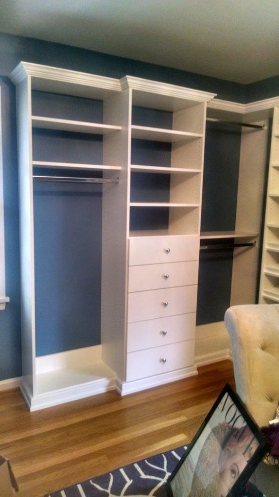 This is an example of a small traditional gender neutral walk-in wardrobe in Louisville with open cabinets, white cabinets, medium hardwood flooring and brown floors.