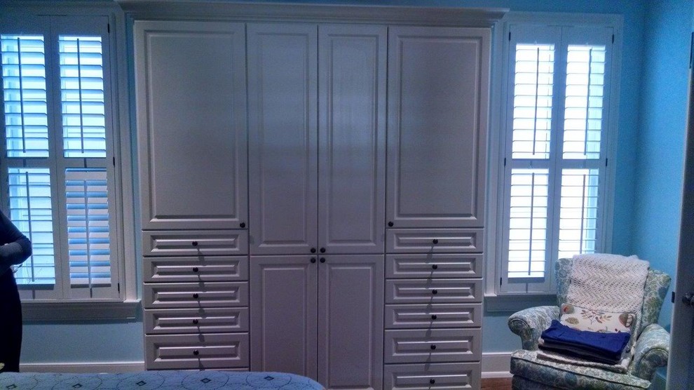 Foto di un piccolo armadio o armadio a muro unisex tradizionale con ante con bugna sagomata, ante bianche, pavimento in legno massello medio e pavimento marrone