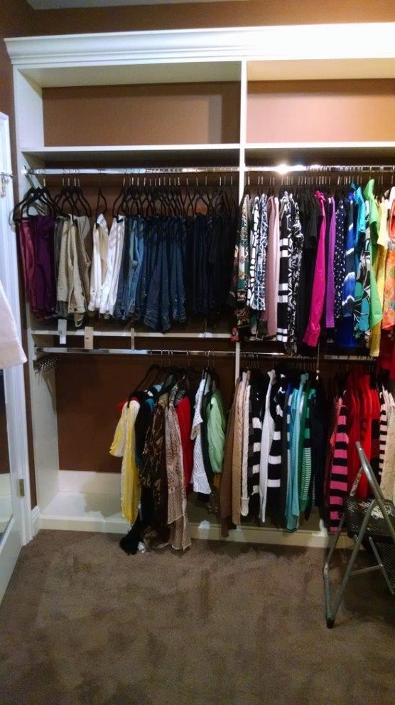 Ejemplo de armario vestidor unisex clásico de tamaño medio con armarios con paneles con relieve, puertas de armario blancas, moqueta y suelo marrón