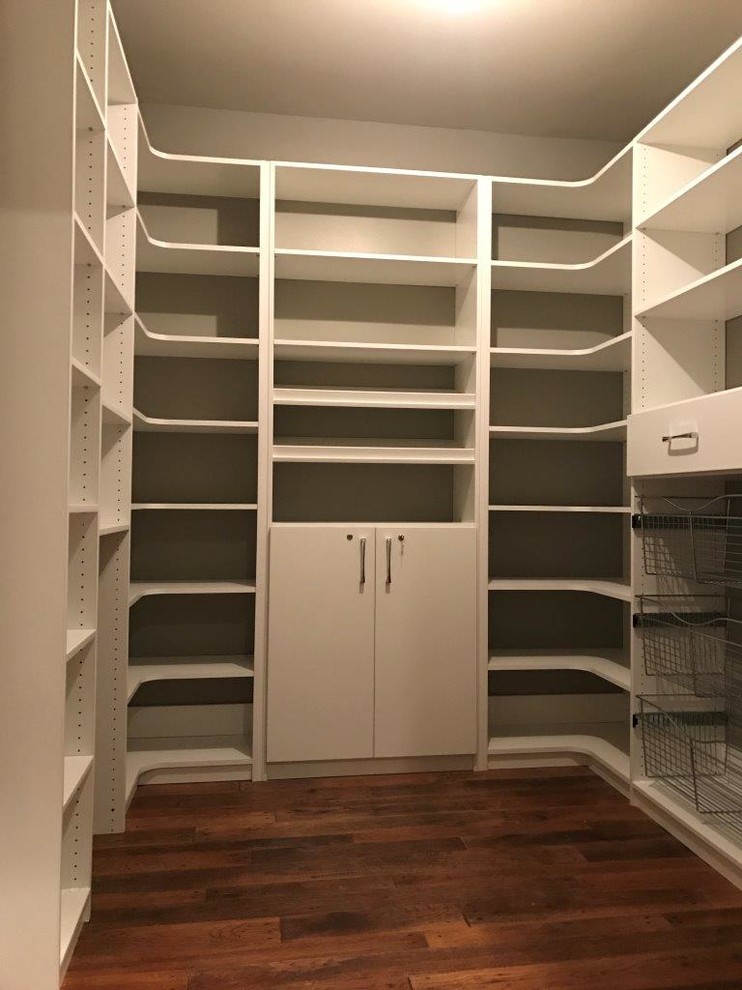 Exempel på ett mellanstort klassiskt walk-in-closet för könsneutrala, med släta luckor, vita skåp, mörkt trägolv och brunt golv