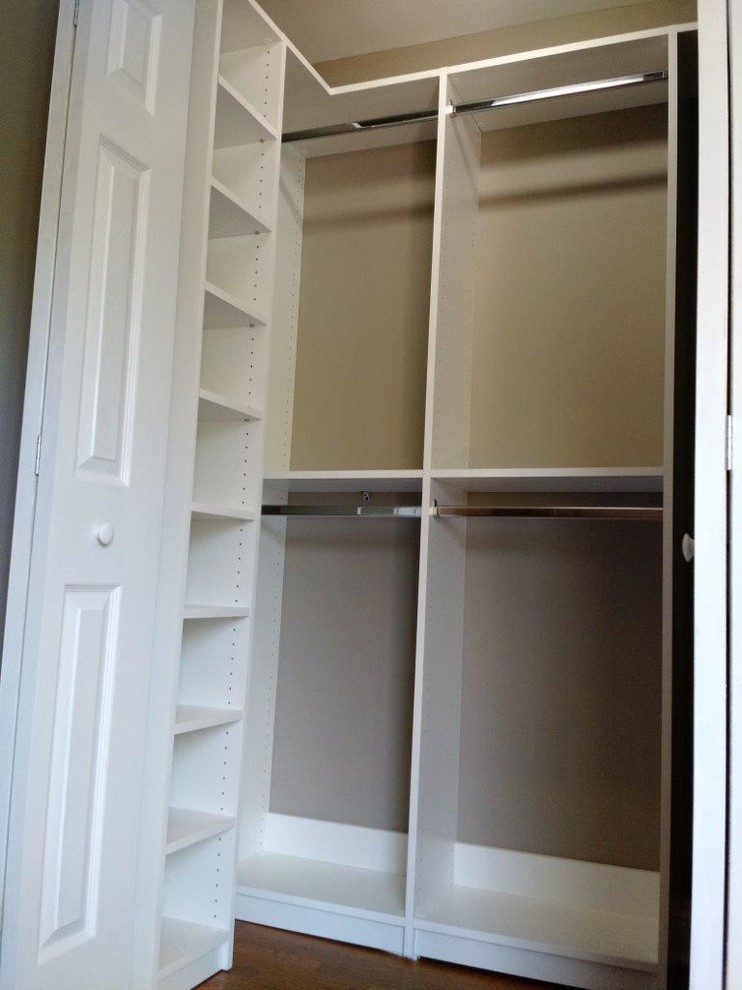 Diseño de armario unisex tradicional pequeño con armarios abiertos, puertas de armario blancas, suelo de madera en tonos medios y suelo marrón