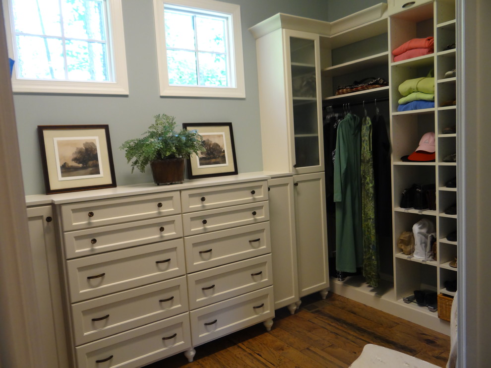 Example of a large classic gender-neutral dark wood floor and brown floor dressing room design in Charlotte with recessed-panel cabinets and white cabinets