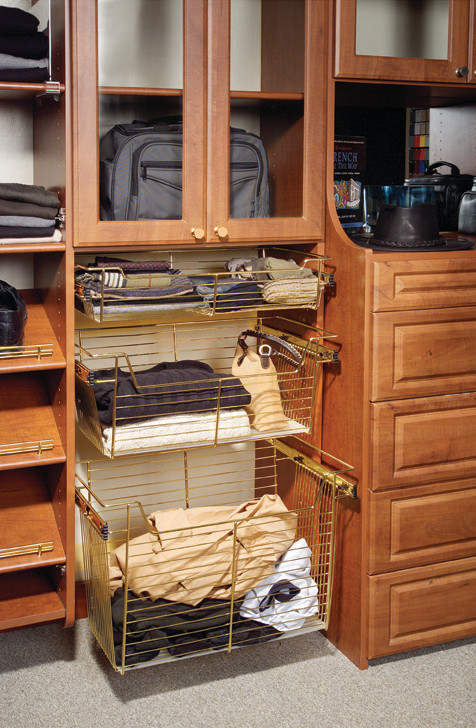 Foto di una cabina armadio per uomo chic di medie dimensioni con ante con bugna sagomata, ante in legno bruno e moquette