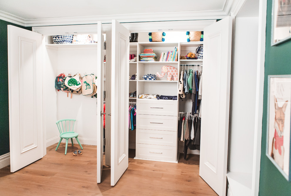 Foto de armario unisex clásico renovado con armarios abiertos, puertas de armario blancas, suelo de madera en tonos medios y suelo marrón