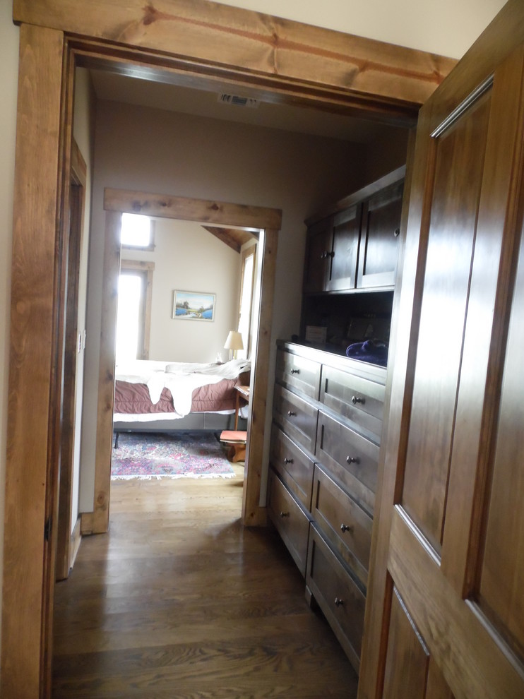Foto de vestidor unisex de estilo de casa de campo de tamaño medio con armarios con paneles empotrados, puertas de armario de madera clara y suelo de madera clara
