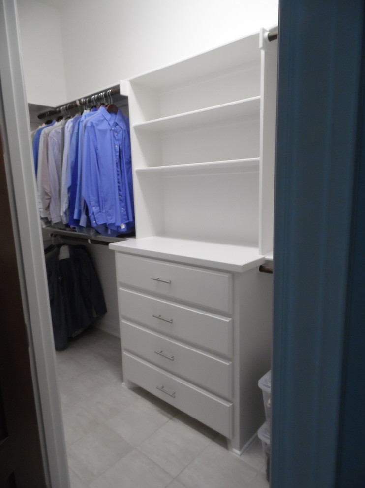 Ejemplo de armario vestidor unisex de estilo americano grande con armarios con paneles con relieve, puertas de armario blancas y suelo de baldosas de porcelana