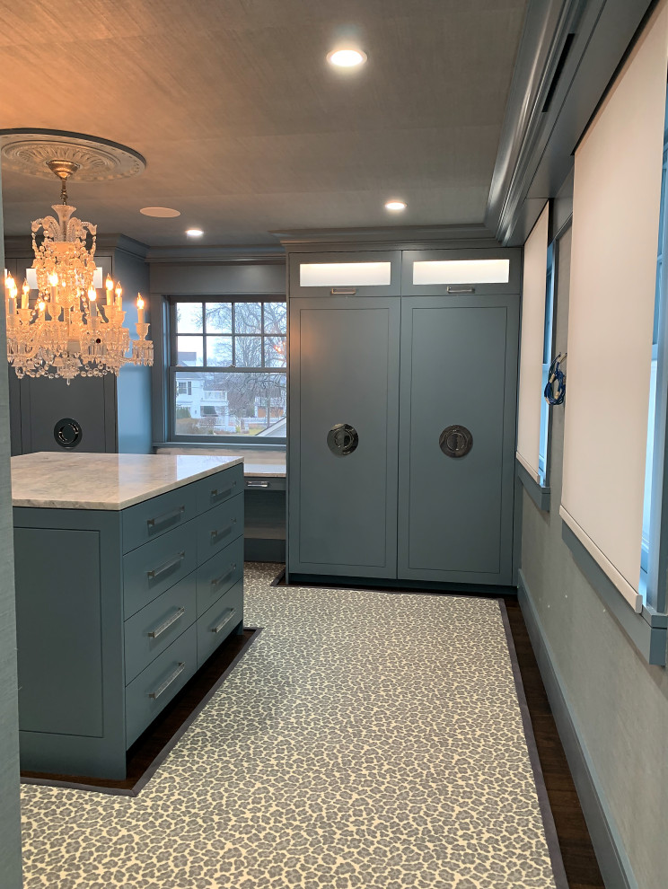 Example of a mid-sized carpeted and wallpaper ceiling walk-in closet design in Bridgeport with flat-panel cabinets and blue cabinets
