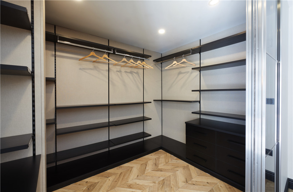 Diseño de armario y vestidor unisex de tamaño medio con a medida, armarios abiertos, puertas de armario negras, suelo de corcho, suelo multicolor y casetón