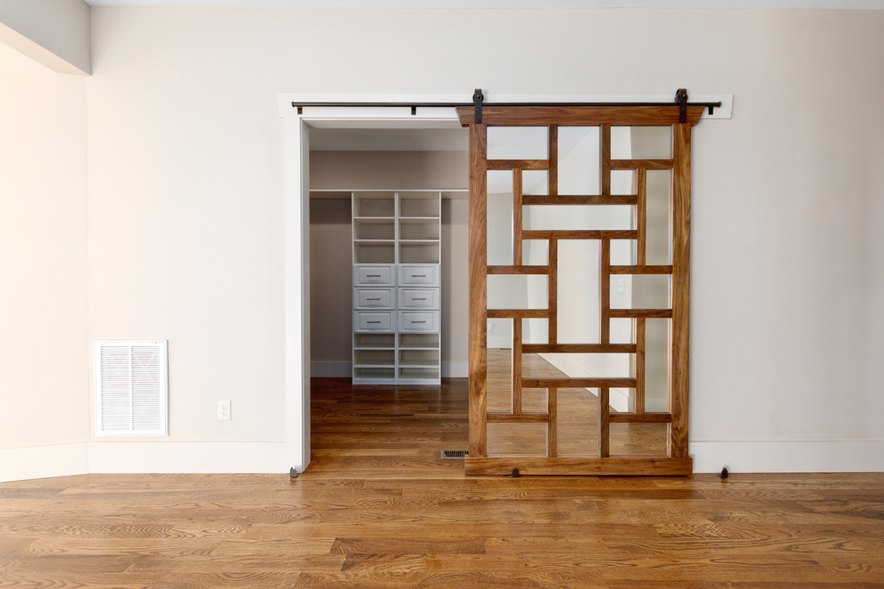 Пример оригинального дизайна: гардеробная комната среднего размера, унисекс в стиле кантри с паркетным полом среднего тона и коричневым полом