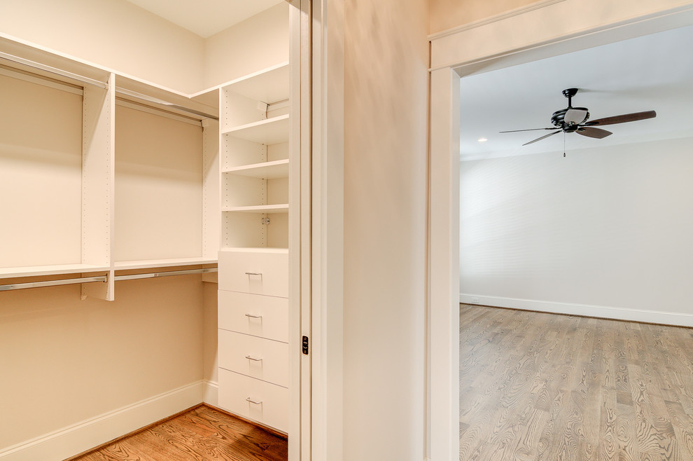 Ejemplo de armario vestidor clásico de tamaño medio con suelo de madera en tonos medios y suelo beige