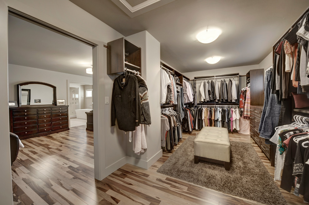 Imagen de armario vestidor unisex moderno grande con armarios con paneles lisos y puertas de armario de madera en tonos medios
