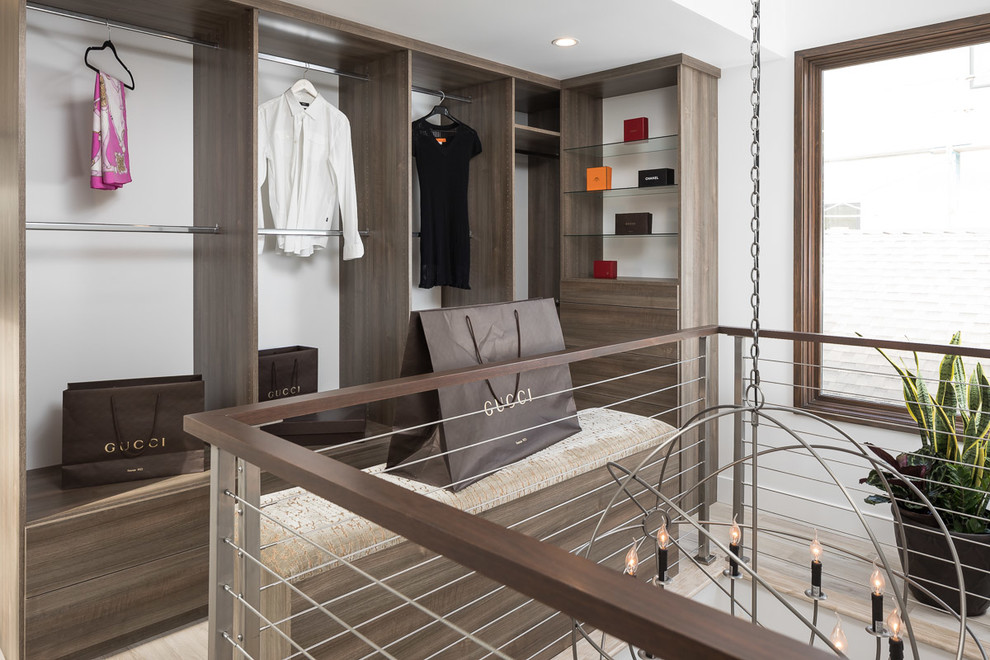 Mittelgroßes, Neutrales Modernes Ankleidezimmer mit Ankleidebereich, flächenbündigen Schrankfronten, hellbraunen Holzschränken und braunem Holzboden in Orange County