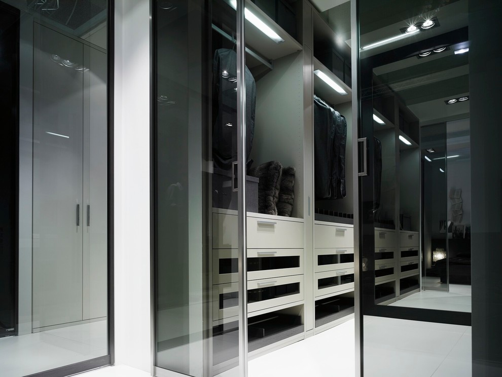 Diseño de armario vestidor unisex moderno de tamaño medio con armarios tipo vitrina, suelo de baldosas de porcelana y puertas de armario grises
