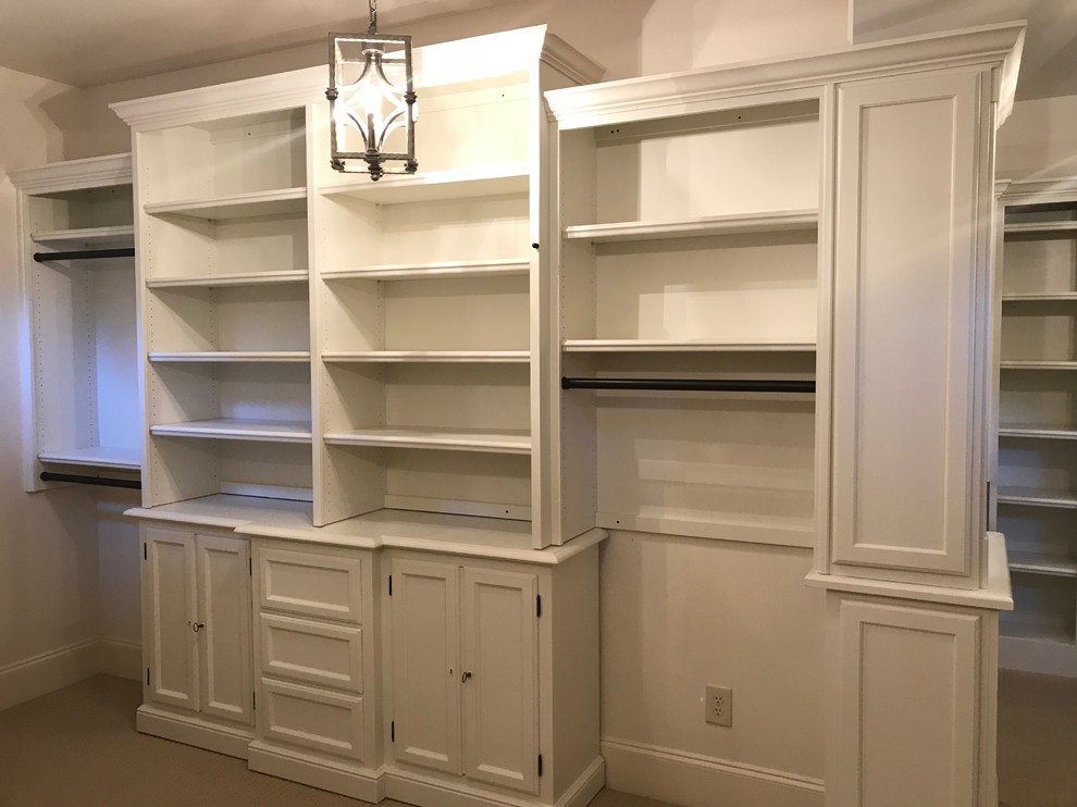 Photo of an expansive traditional gender neutral walk-in wardrobe in Atlanta with recessed-panel cabinets, white cabinets, carpet and beige floors.