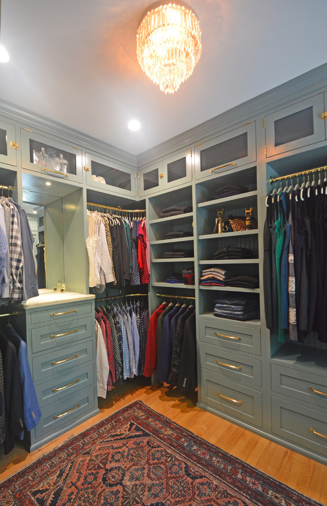 Ejemplo de armario vestidor unisex clásico renovado de tamaño medio con armarios con paneles empotrados, puertas de armario grises y suelo de madera clara