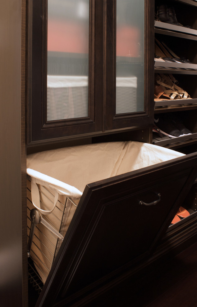 Idée de décoration pour un petit dressing tradition en bois foncé pour une femme avec un placard avec porte à panneau surélevé et parquet foncé.