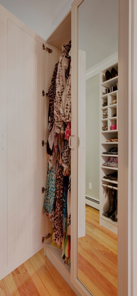 Modelo de armario vestidor de mujer tradicional grande con suelo de madera clara, suelo beige, armarios con paneles empotrados y puertas de armario de madera clara