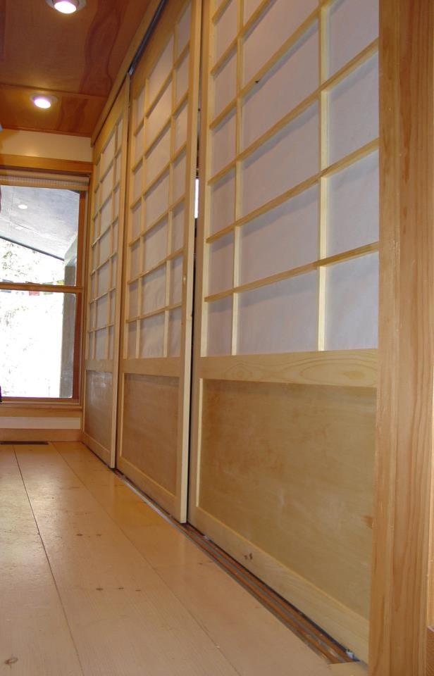 Réalisation d'un placard dressing asiatique en bois clair de taille moyenne et neutre avec un placard avec porte à panneau encastré et parquet clair.