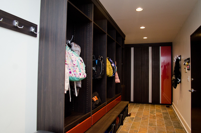 На фото: большая гардеробная комната унисекс в современном стиле с открытыми фасадами, коричневыми фасадами и полом из терракотовой плитки с