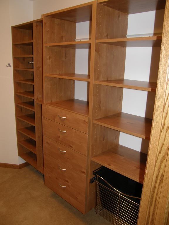 Photo of a large classic walk-in wardrobe in Minneapolis with flat-panel cabinets, medium wood cabinets, carpet and brown floors.