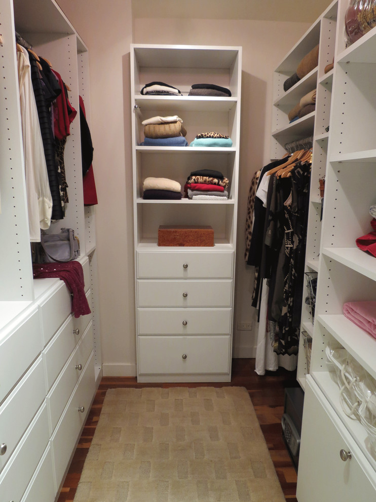 Imagen de armario vestidor unisex tradicional de tamaño medio con armarios con paneles con relieve, puertas de armario blancas y suelo de madera oscura
