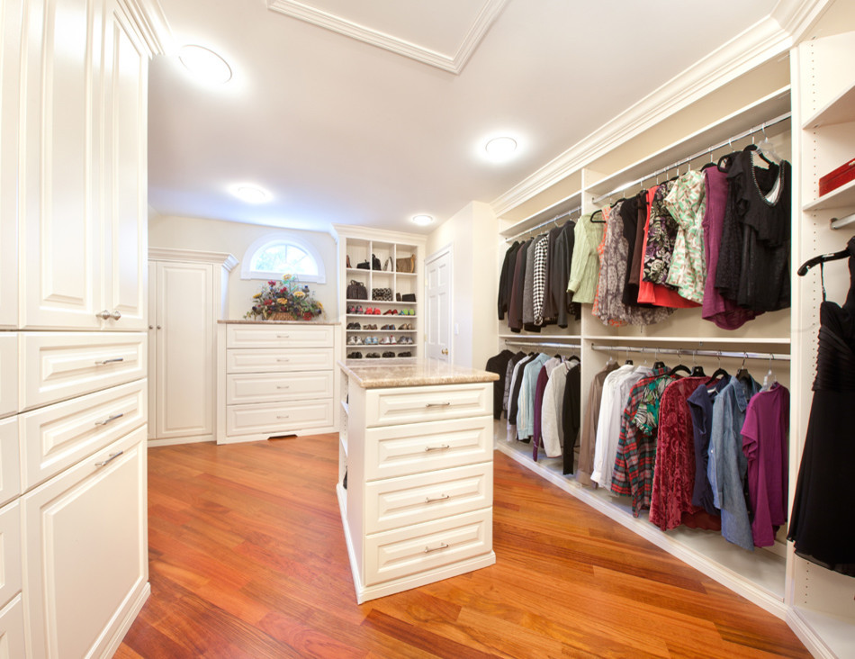 Foto de armario vestidor tradicional extra grande con armarios con paneles con relieve, puertas de armario blancas y suelo de madera en tonos medios