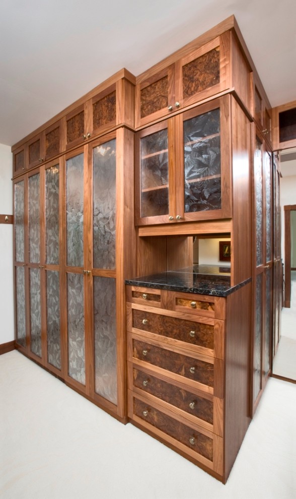 Ejemplo de armario vestidor clásico extra grande con armarios tipo vitrina, puertas de armario de madera en tonos medios y moqueta