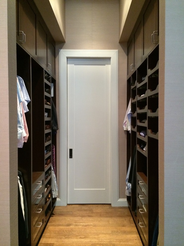 Diseño de vestidor de hombre tradicional de tamaño medio con armarios con paneles empotrados, puertas de armario de madera en tonos medios y suelo de madera en tonos medios