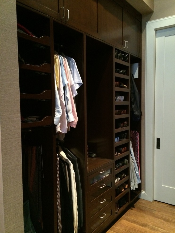 Dressing room - mid-sized traditional men's medium tone wood floor dressing room idea in New York with recessed-panel cabinets and dark wood cabinets