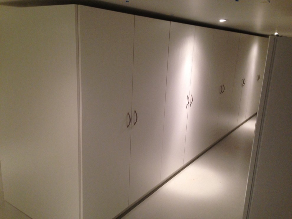 Immagine di un armadio o armadio a muro unisex tradizionale di medie dimensioni con ante lisce, ante bianche, moquette e pavimento beige