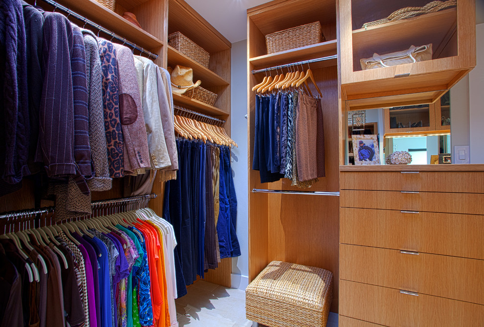 Modelo de armario vestidor unisex contemporáneo de tamaño medio con armarios con paneles lisos, puertas de armario de madera clara y suelo de baldosas de cerámica