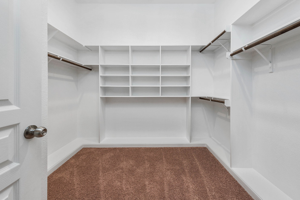 Design ideas for a large traditional gender neutral walk-in wardrobe in Austin with open cabinets, white cabinets, carpet and beige floors.