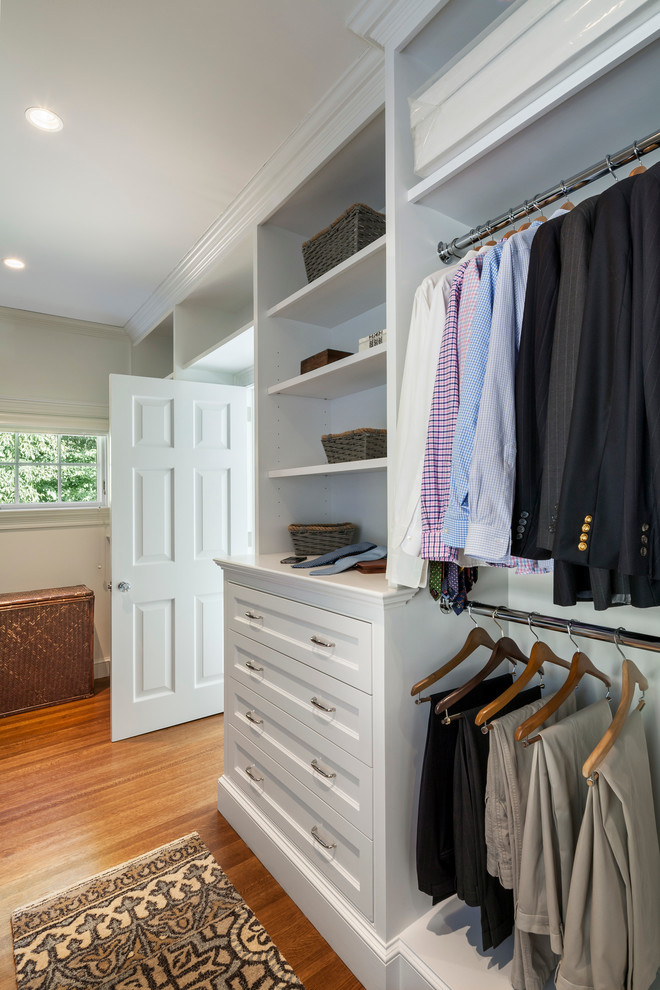 Modelo de armario y vestidor de hombre clásico de tamaño medio con puertas de armario blancas y suelo de madera en tonos medios