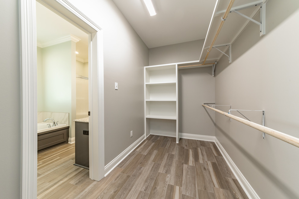 На фото: гардеробная комната среднего размера, унисекс в стиле кантри с полом из керамической плитки и серым полом