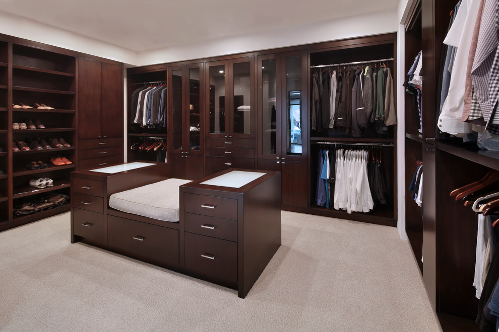 Aménagement d'un dressing room classique en bois foncé pour un homme avec moquette, un sol beige et un placard sans porte.