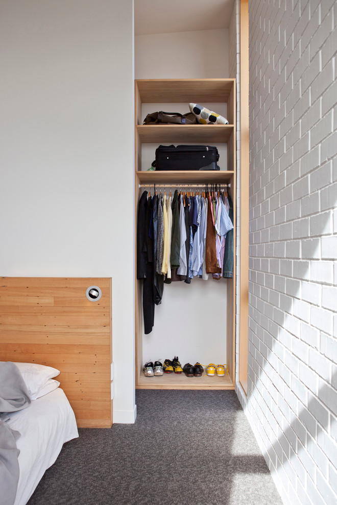 Reach-in closet - small contemporary gender-neutral carpeted reach-in closet idea in Auckland with open cabinets and light wood cabinets