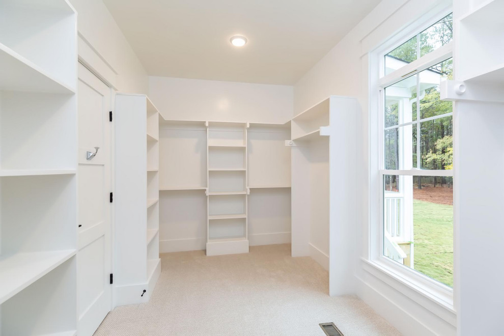 Inspiration for a large cottage gender-neutral carpeted and beige floor built-in closet remodel in Raleigh with open cabinets and white cabinets