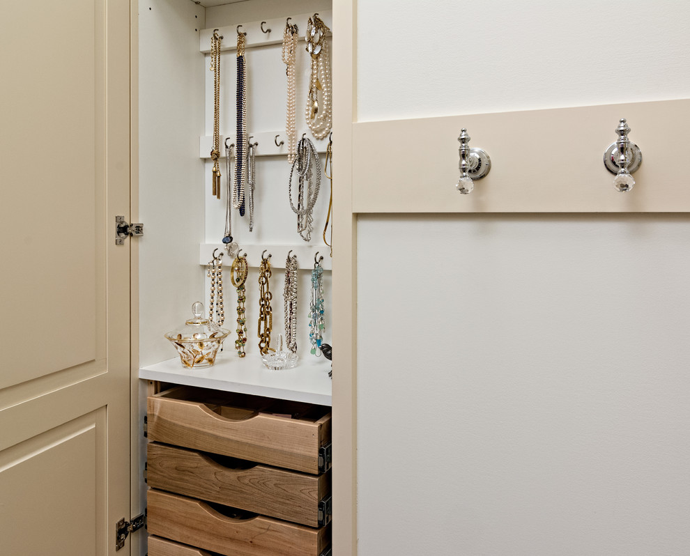 Ejemplo de armario y vestidor de mujer tradicional de tamaño medio con armarios con paneles con relieve y puertas de armario beige