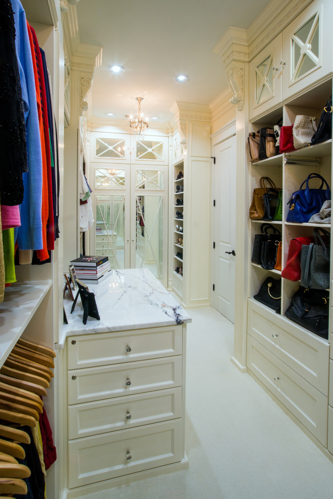 Inspiration for a large transitional gender-neutral carpeted and beige floor walk-in closet remodel in Charlotte with recessed-panel cabinets and white cabinets