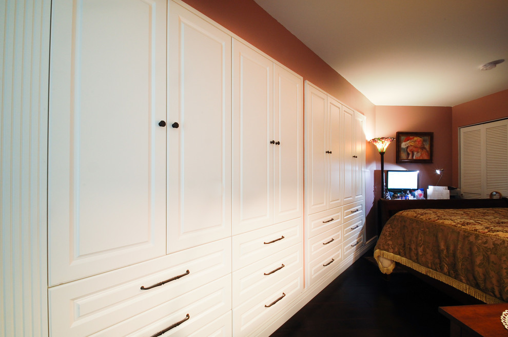 На фото: шкаф в нише среднего размера в классическом стиле с фасадами с выступающей филенкой, белыми фасадами и темным паркетным полом для женщин с