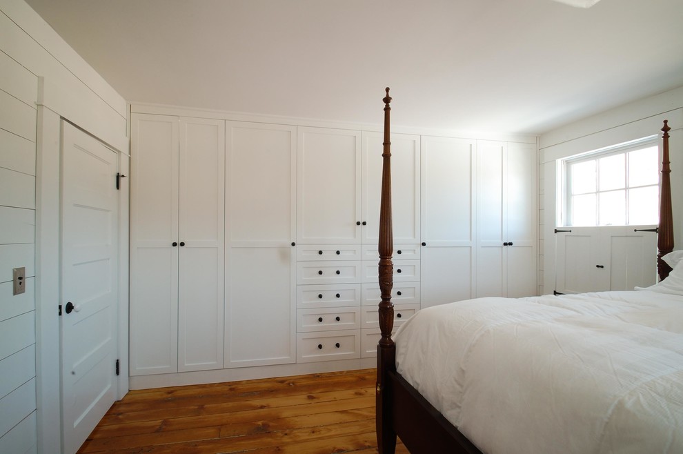 Foto di uno spazio per vestirsi unisex classico di medie dimensioni con ante in stile shaker, ante bianche e pavimento in legno massello medio