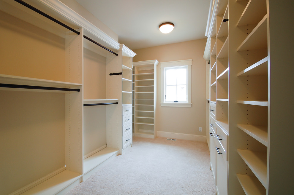 This is an example of a large classic gender neutral walk-in wardrobe in Minneapolis with shaker cabinets, white cabinets and carpet.