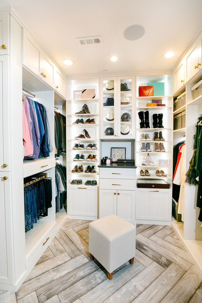 Photo of an expansive classic gender neutral walk-in wardrobe in Sacramento with flat-panel cabinets, white cabinets, medium hardwood flooring and grey floors.