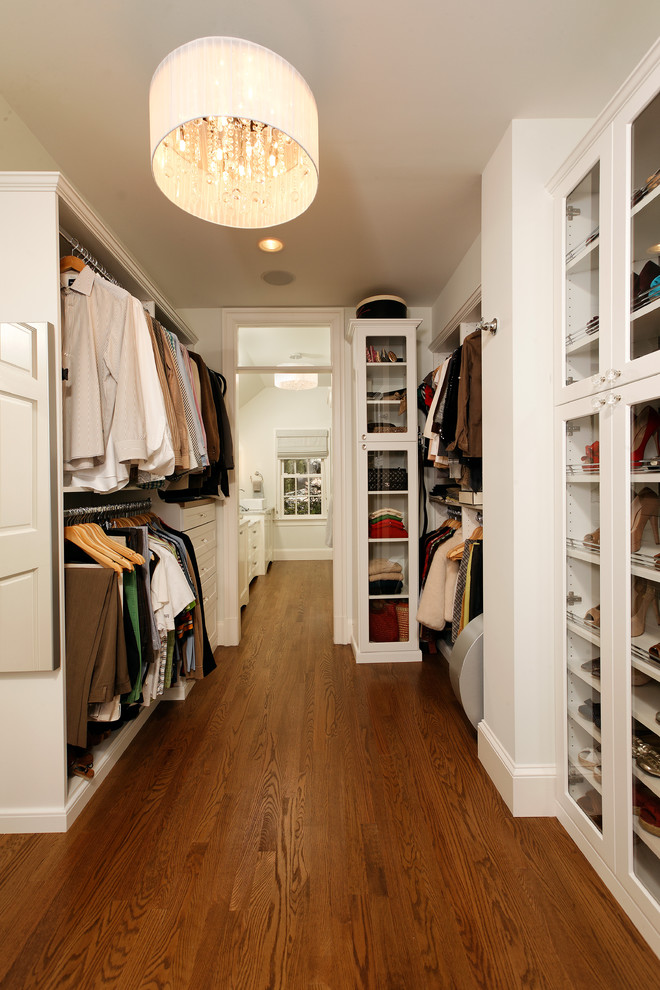 Example of a classic medium tone wood floor closet design in DC Metro with white cabinets