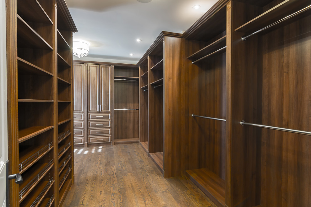 Example of a mid-sized trendy dark wood floor and brown floor walk-in closet design in Toronto with open cabinets and dark wood cabinets