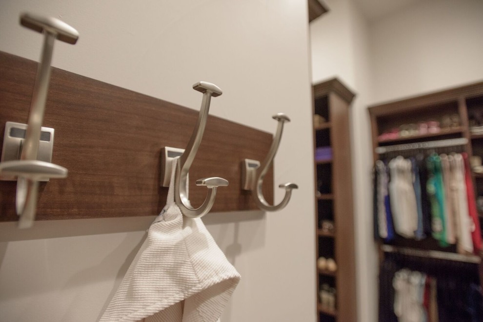This is an example of a traditional gender neutral walk-in wardrobe in Denver with open cabinets, dark wood cabinets, carpet and beige floors.