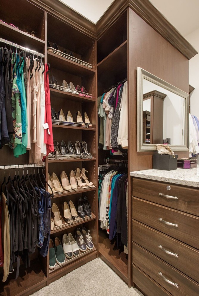 Walk-in closet - traditional gender-neutral carpeted and beige floor walk-in closet idea in Denver with open cabinets and dark wood cabinets