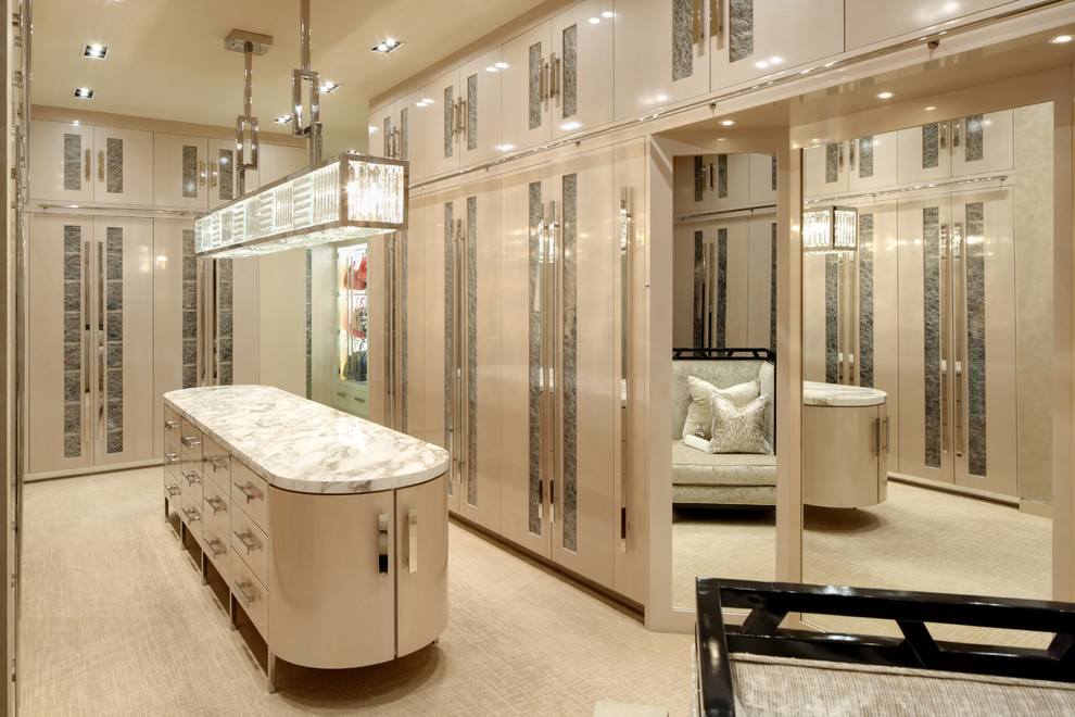 Immagine di un'ampia cabina armadio per donna design con ante beige, moquette, pavimento beige e ante lisce
